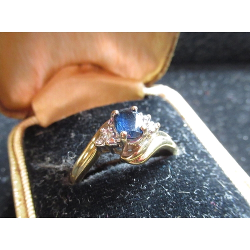 6 - 9ct yellow gold sapphire ring with an oval cut, claw set sapphire flanked by diamonds claw set in a ... 