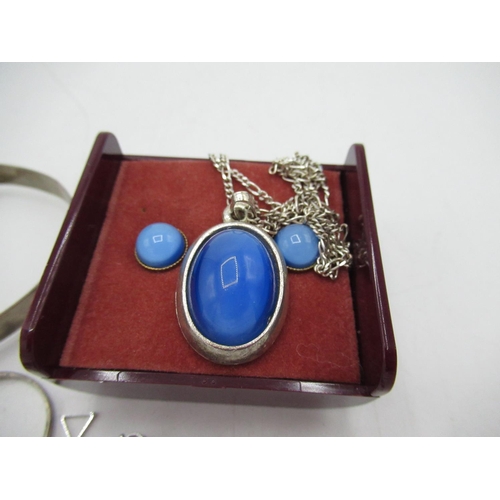 24 - Blue stone inset in a white metal circular pendant on a sterling silver Figaro chain, stamped 925, a... 