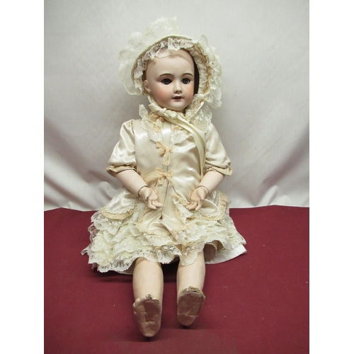 882 - SFBJ French bisque headed doll model 301, with peirced ears and articulated limbs, wearing lace trim... 