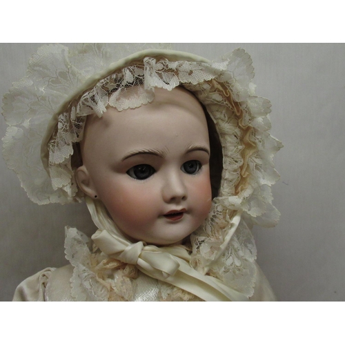 882 - SFBJ French bisque headed doll model 301, with peirced ears and articulated limbs, wearing lace trim... 