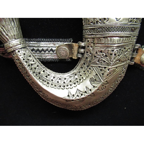 91 - Framed and mounted display of Middle Eastern jambiya complete with belt and pouches, with white meta... 