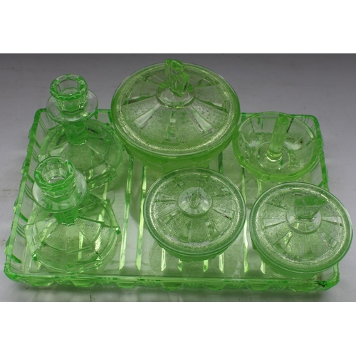 281 - Art Deco bedroom set in green glass comprising tray, candlesticks, pin tray, and lidded jars