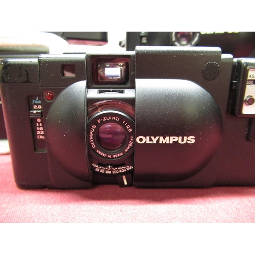 150 - Three Olympus XA Rangefinder cameras including flash guns