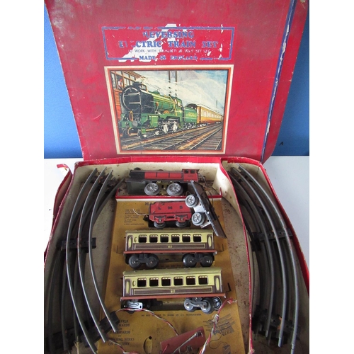 589 - Tinplate reversing battery operated electric train set, in original box with locomotive, tender, two... 