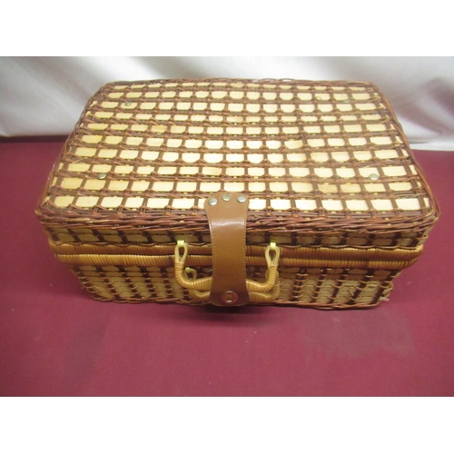 409 - Wicker picnic basket with checked interior, a set of four plastic plates, mugs and cutlery and anoth... 