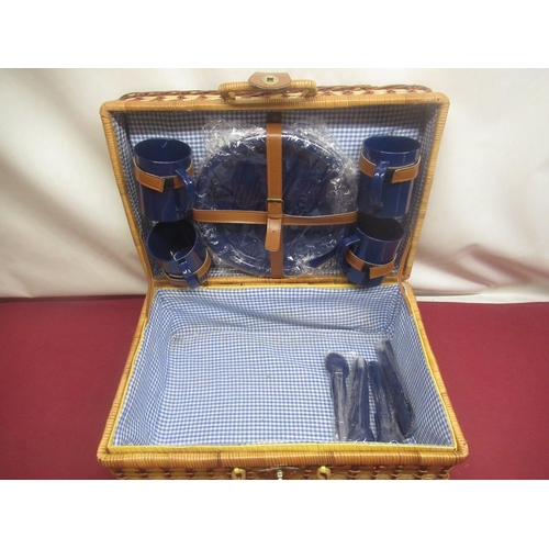 409 - Wicker picnic basket with checked interior, a set of four plastic plates, mugs and cutlery and anoth... 
