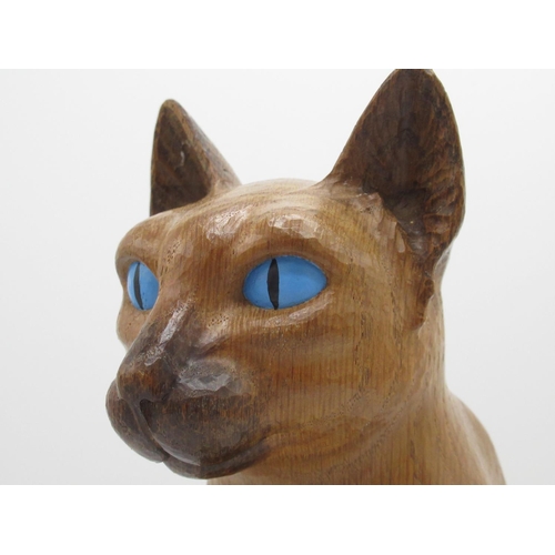 1411 - Robert Mouseman Thompson of Kilburn - a carved oak model of a Siamese cat with blue eyes, seated wit... 