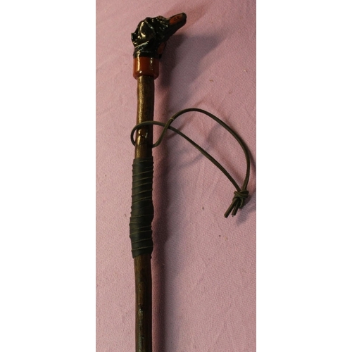 129 - An ash shank walking stick with leather wrapped handle and thong and painted carved Daschund like do... 