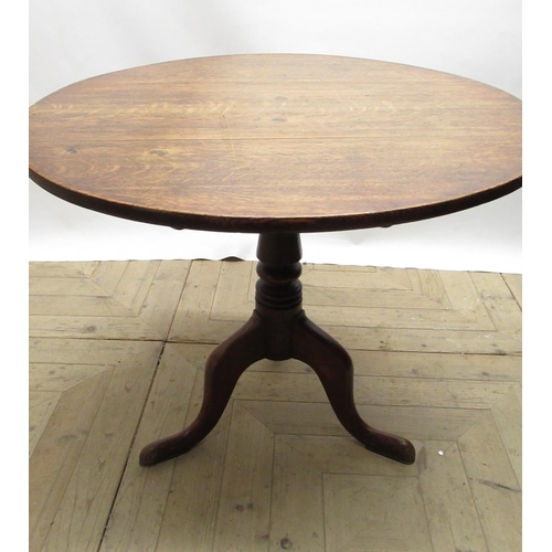 562 - Geo.III oak tripod tea table, circular tilt top on vase turned column support and three outsplayed c... 