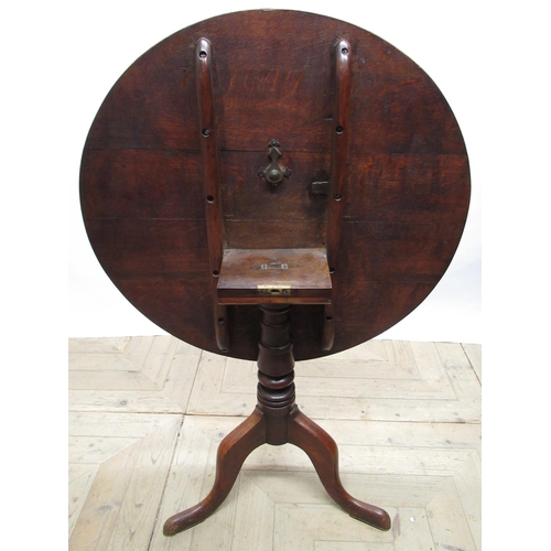 562 - Geo.III oak tripod tea table, circular tilt top on vase turned column support and three outsplayed c... 