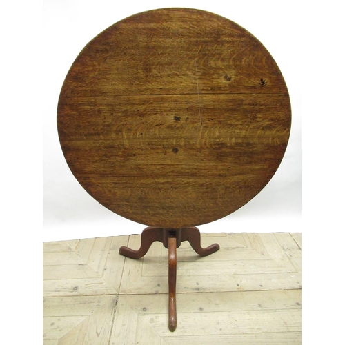 562 - Geo.III oak tripod tea table, circular tilt top on vase turned column support and three outsplayed c... 