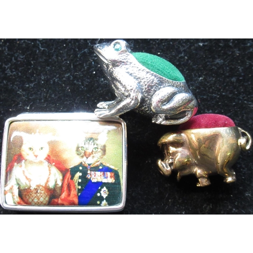 71 - Brass pig pincushion, silver pill box with enamel lid depicting royal cats, and a silver pin cushion... 