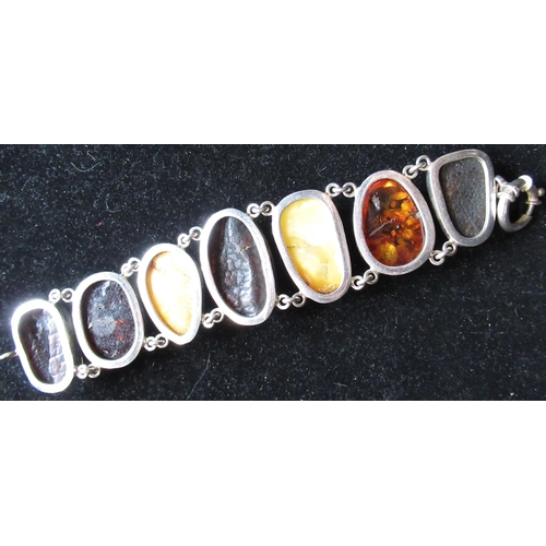 3 - Hallmarked silver and amber bracelet, seven three tone butterscotch, orange and green amber beads mo... 