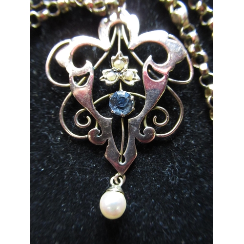 27 - 9ct yellow gold openwork pendant set with seed pearls and a claw set blue stone on a 9ct yellow gold... 