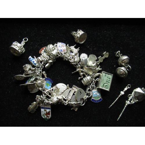 58 - Sterling silver charm bracelet with heart padlock clasp with a variety of silver and white metal cha... 