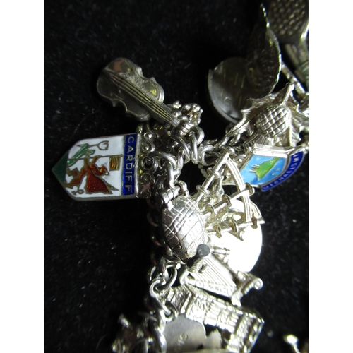 58 - Sterling silver charm bracelet with heart padlock clasp with a variety of silver and white metal cha... 