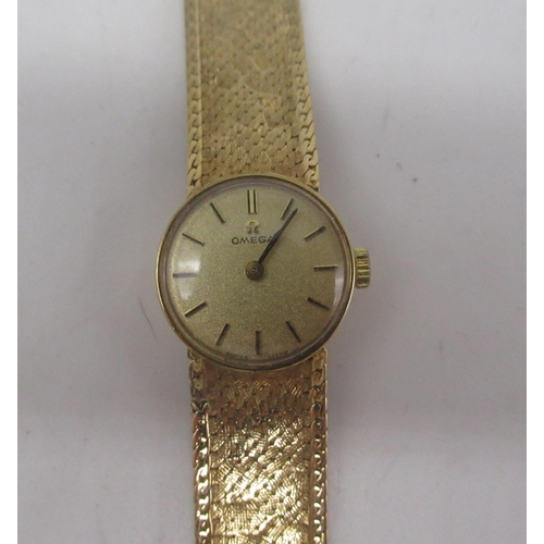 1064 - Ladies Omega 9ct gold hand wound wristwatch, signed brushed gold dial with applied baton markers, tw... 