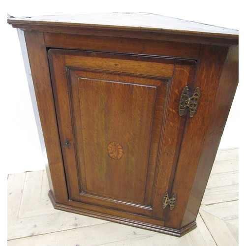 590 - Geo. III oak corner cabinet, with moulded cornice above mahogany cross banded panel door inlaid with... 