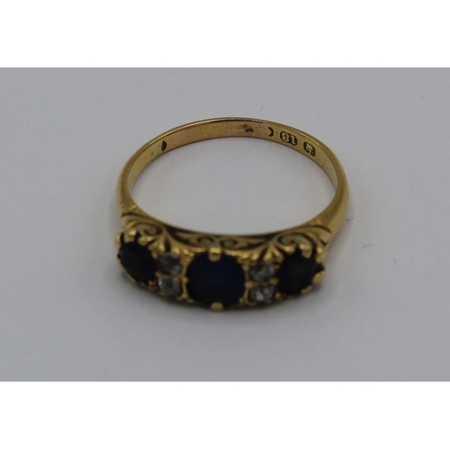 1027 - 18ct yellow gold ring set with three sapphires and four diamonds in engraved mount, stamped 18ct, si... 