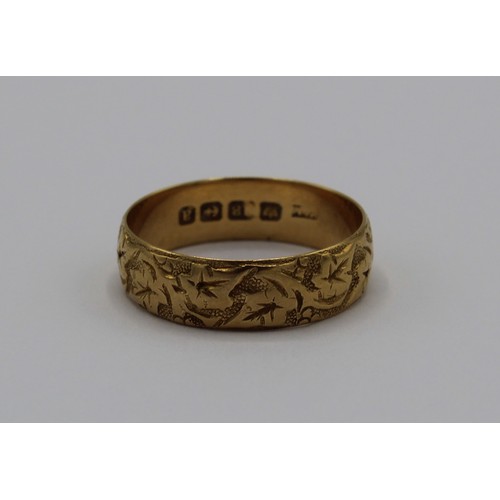 1031 - 18ct yellow gold wedding band with foliage engraved design, stamped 18ct, size U, 4.7g
