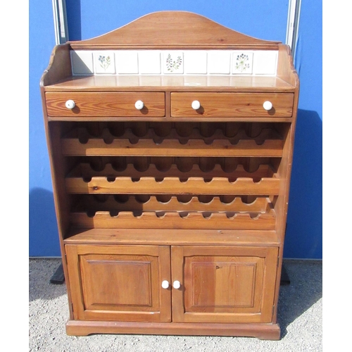 1302 - Waxed pine kitchen cabinet, arched tiled back above two drawers, 24 bottle wine rack and two doors o... 