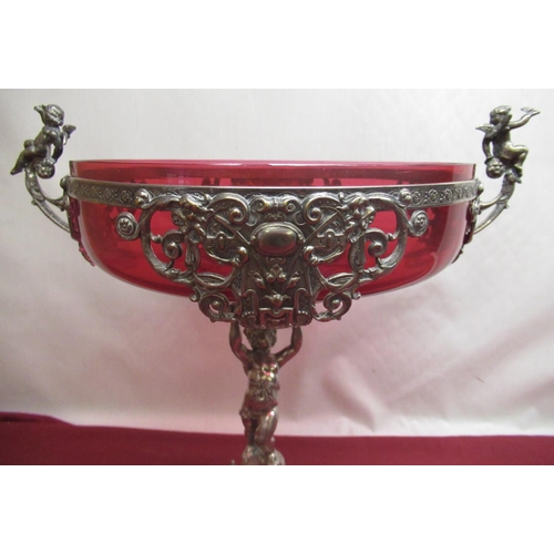 1053 - WMF silver plated table centre, the circular top with cranberry glass liner and figural handles, sup... 