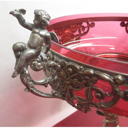 1053 - WMF silver plated table centre, the circular top with cranberry glass liner and figural handles, sup... 