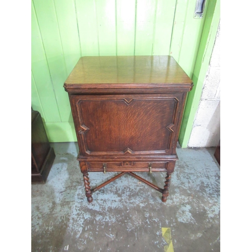 1341 - Early C20th oak drinks cabinet with swivel folding baise lined top, the moulded panel door with swin... 