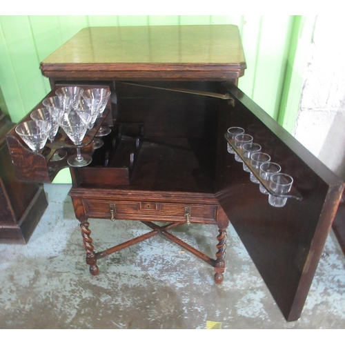 1341 - Early C20th oak drinks cabinet with swivel folding baise lined top, the moulded panel door with swin... 