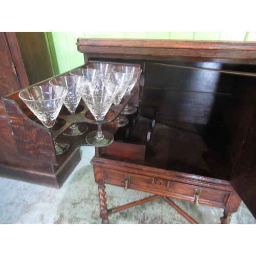 1341 - Early C20th oak drinks cabinet with swivel folding baise lined top, the moulded panel door with swin... 