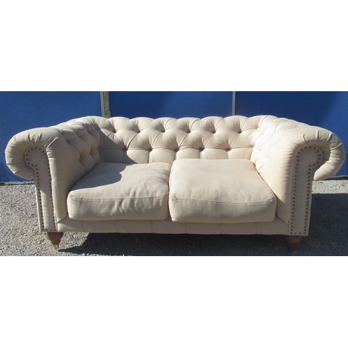 1332 - Chesterfield sofa, buttoned back and arms with two loose seat cushions on turned supports, W180cm D1... 