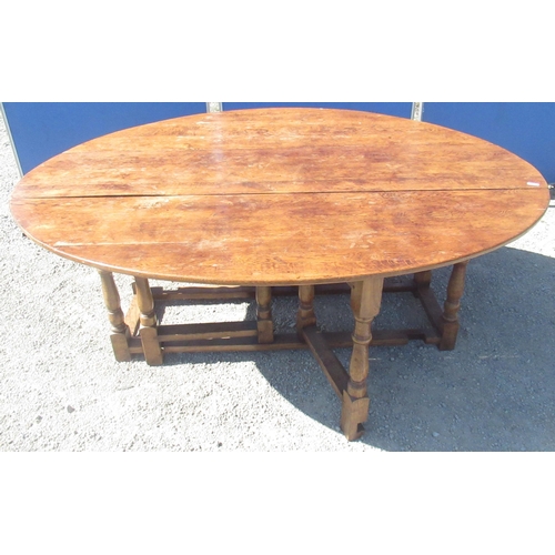 1292 - C17th style oak Wake table, oval top with two fall leaves on twin gate baluster turned and block sup... 
