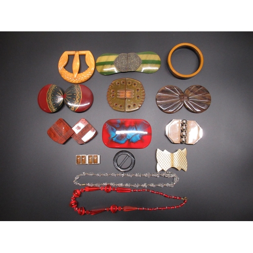21 - Collection of early C20th and later belt buckles and jewellery including a Bakelite black and orange... 