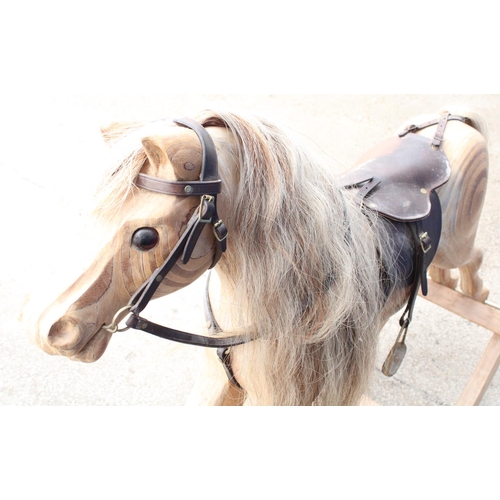 869 - C20th rocking horse, ply construction on bow rocker base, cream mane and tail with leather saddle, b... 
