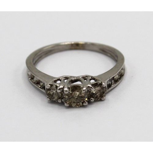 250 - White gold diamond ring, the three central round cut diamonds set on a half eternity band, stamped 1... 