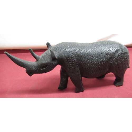 316 - Ebonised wooden model of a rhino and two terracotta lion figures (3)