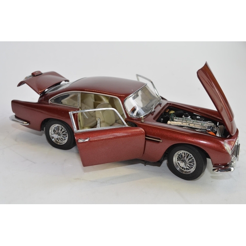 874 - 3 boxed 1/24 scale die-cast european car models:
A Danbury Mint 1964 Aston Martin DB5, box fair, no ... 