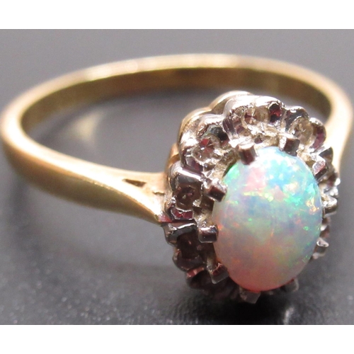 19 - yellow metal opal and diamond ring, the central oval opal surrounded by a halo of diamonds, unmarked... 
