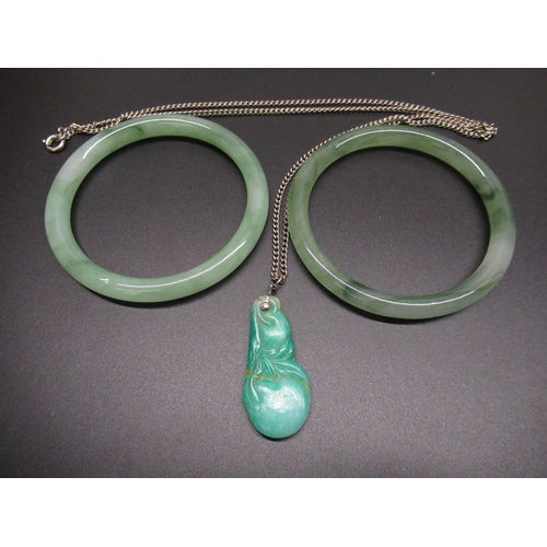 42 - Pair of jade bangles, D7.4cm, and a carved jade pendant in the form of fruit (A/F) on white metal ch... 