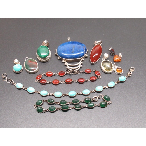 57 - Collection of nine Sterling silver pendants set with various stones including lapis lazul and three ... 