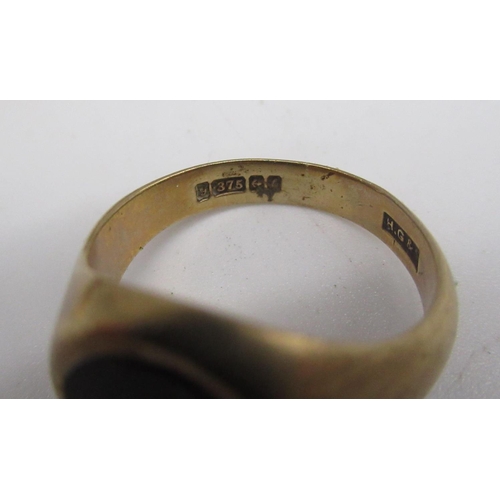 704 - 9ct yellow gold signet ring, the oval face set with black stone, stamped 375, 5.9g, a hallmarked Ste... 