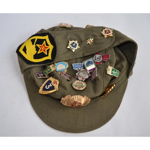 292 - A collection of mostly Russian caps with a large number of badges attached, many naval and parachute... 