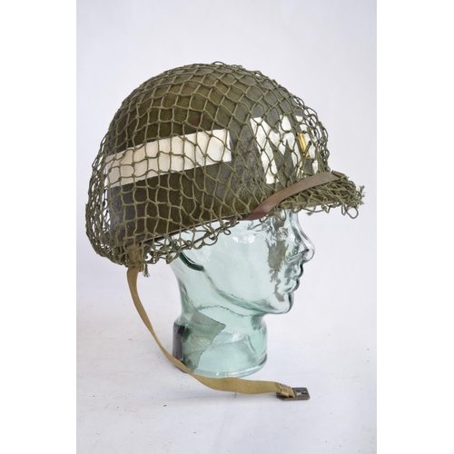 472 - A US Army WWII M1 Mk1 front seam steel helmet, with liner, chin straps etc. With 2nd Lieutenant bar ... 