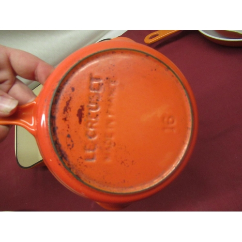 128 - Pair of Le Creuset volcanic orange cast iron round skillets, no. 16, D16.5cm, larger skillet no. 23,... 