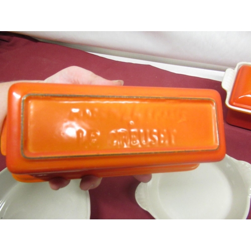 129 - Le Creuset volcanic orange rectangular lidded casserole no. 32, W34cm D11.5cm H12cm, a smaller lidde... 