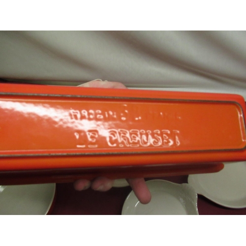 129 - Le Creuset volcanic orange rectangular lidded casserole no. 32, W34cm D11.5cm H12cm, a smaller lidde... 