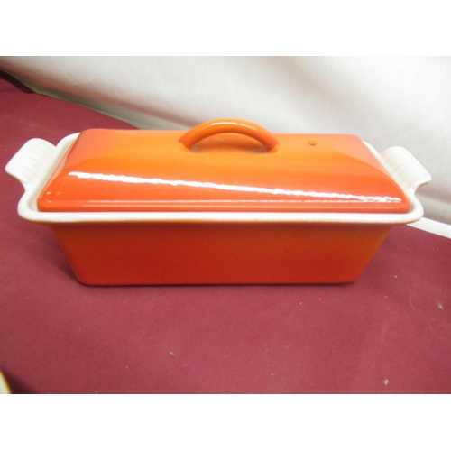 129 - Le Creuset volcanic orange rectangular lidded casserole no. 32, W34cm D11.5cm H12cm, a smaller lidde... 