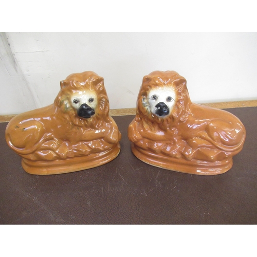 179 - Pair of Staffordshire type models of recumbant lions, with inset eyes, W28cm H25cm (2)
