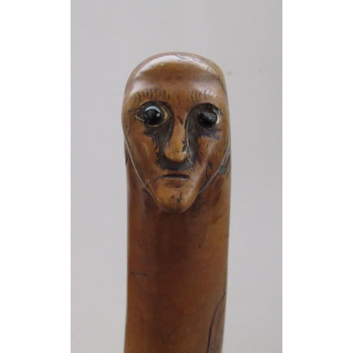 144 - Victorian naïve walking stick, handle carved as a male face with glass eyes, all over penwork decora... 