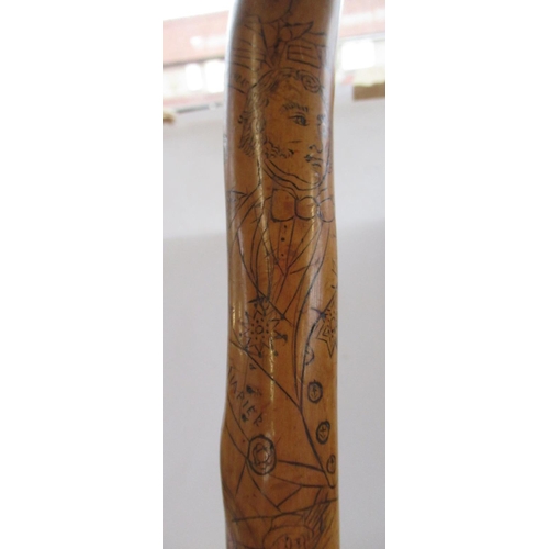 144 - Victorian naïve walking stick, handle carved as a male face with glass eyes, all over penwork decora... 